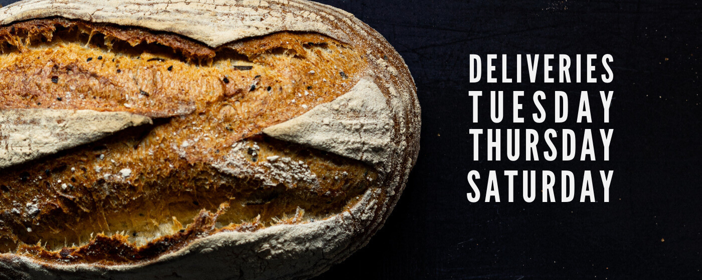 An image of sourdough bread. To the right of the image reads 'deliveries on Tuesday, Thursday and Saturday'.